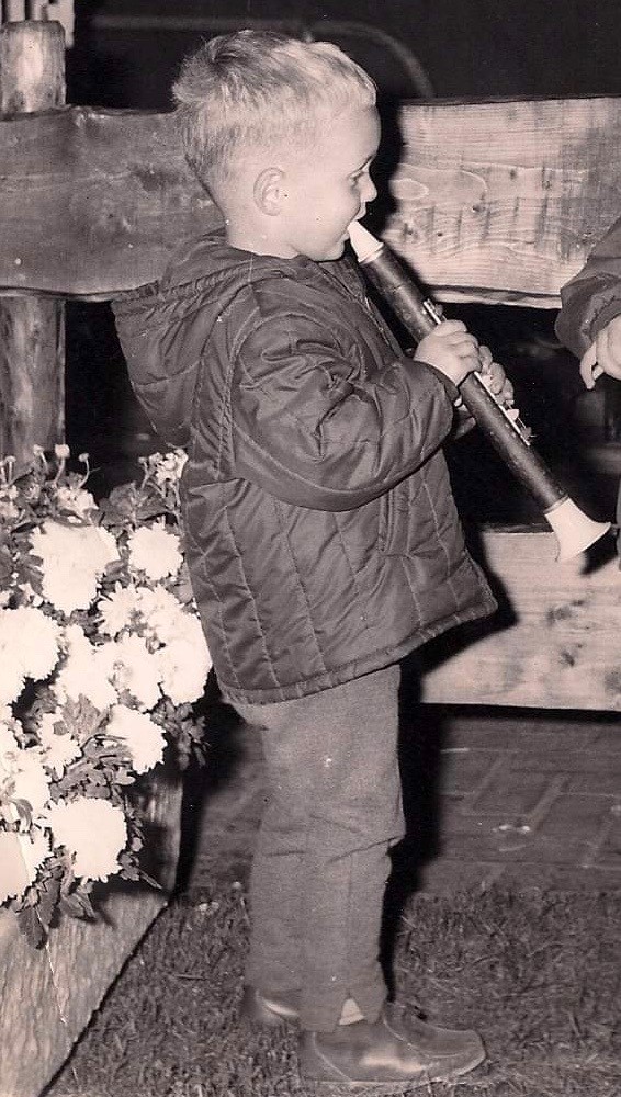 Een kind met een klarinet in zijn handen.